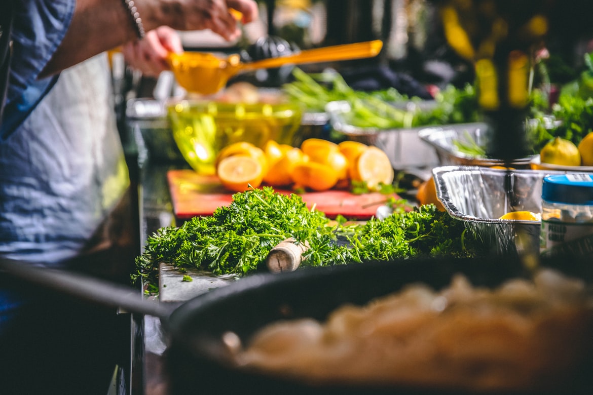 Person in front of table covered in fruits and vegetables.